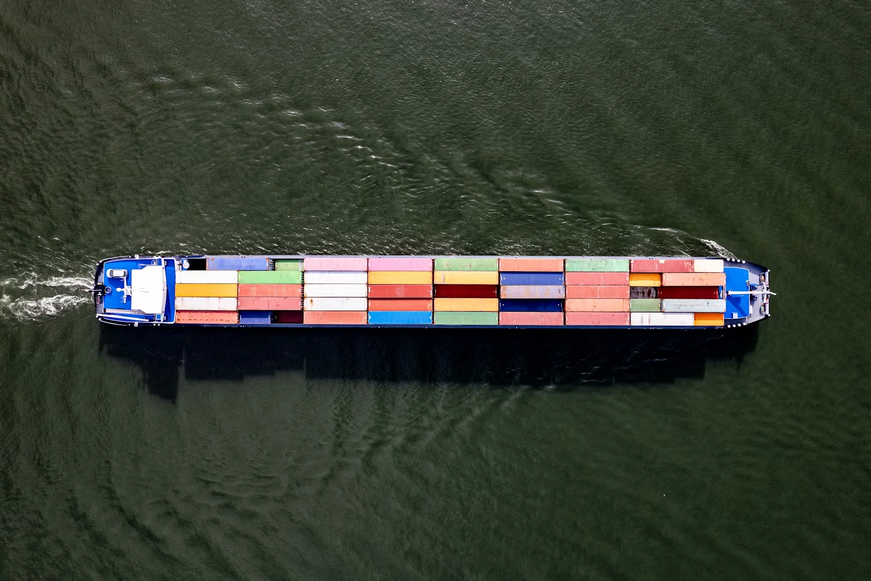 Container cargo ship loaded with freight navigating through water